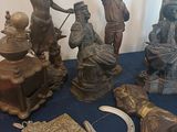 a lot of bronze figurines sitting on a blue table