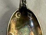 a silver spoon with a picture on it sitting on a table