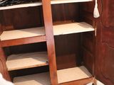 a tall wooden cabinet with shelves in the corner of the room