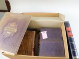 une boîte remplie de livres et un stylo posés sur une table