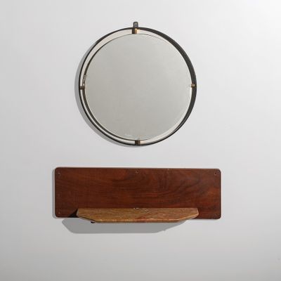 un miroir accroché au mur au-dessus d'une étagère
