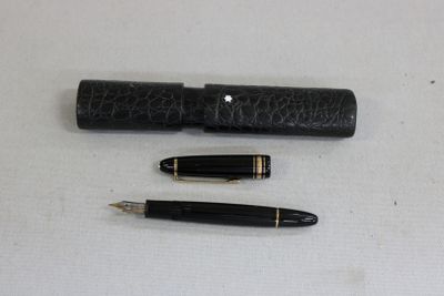 two pens and a pen holder on a table
