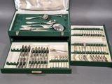 un coffret vert contenant de l'argenterie sur une table