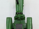 a green toy tractor that is sitting on a white surface