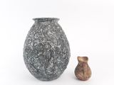 two vases sitting next to each other on a white surface