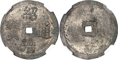 a close up of two silver coins on a white surface