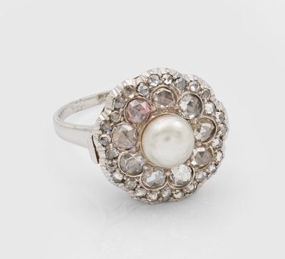 gros plan d'une bague en perles et diamants sur fond blanc