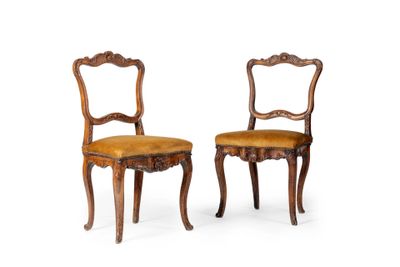 a pair of carved wood chairs with upholstered seats
