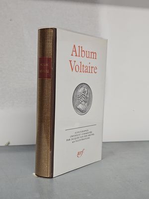 Le livre est posé sur la table près du mur.