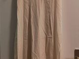une robe de couleur crème suspendue à un cintre dans une pièce