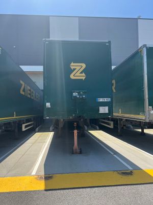 three green semi trucks parked in a parking lot