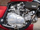 a red motorcycle parked in front of a brick wall