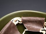 a green bowl with a brown leather bag in it