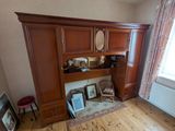 une armoire en bois surmontée d'un miroir, dans une pièce