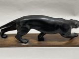 an image of a statue of a black cat on a wooden base