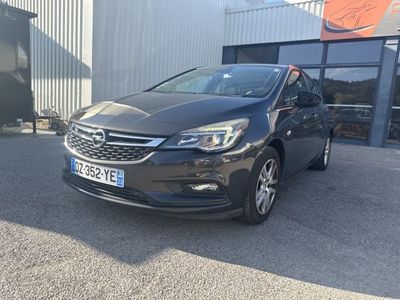 une Opel noire garée devant un immeuble