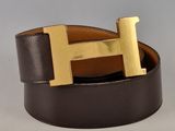 La ceinture est dotée d'une boucle en forme de « H » dorée et est en cuir marron avec une boucle dorée.