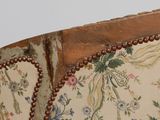 a close up of a floral upholstered chair with beaded trim