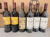 six bouteilles de vin sont alignées sur une table
