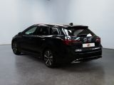 the rear end of a black car parked in a garage