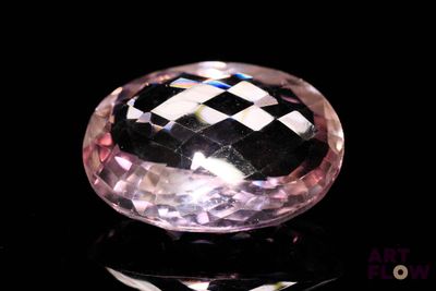 a close up of a pink diamond on a black surface