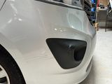 a small white car parked in a garage