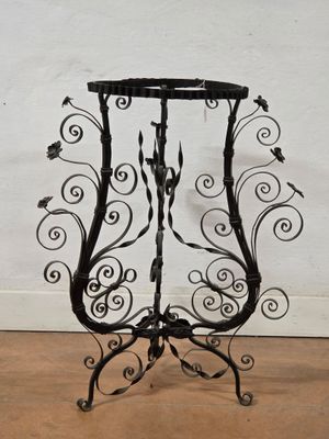 an image of a wrought iron plant stand with a bird on it