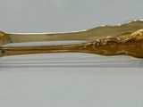 a gold plated spoon and spoon rest on a table