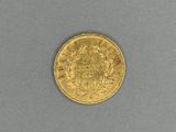 a close up of a gold coin on a gray surface