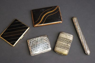 trois types différents d'étuis à cigarettes et un briquet posés sur une table