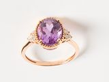an image of a ring with a large amethorate surrounded by small diamonds