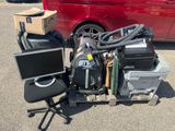 a pile of assorted electronics on a cart in a parking lot