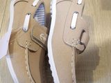 pair of tan leather shoes with white soles on a wooden floor