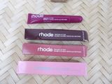 three different shades of lipstick are lined up on a woven surface
