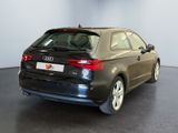 the rear end of a black audi car in a showroom