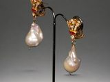 a pair of earrings with pearls and gold