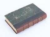 an old book that is sitting on a white surface