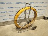 an image of a hose on a cart in front of a wall