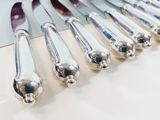 a lot of knives that are lined up on a table