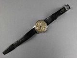 a close up of a watch on a table with a white background