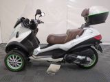 a motor scooter that is parked on a black and white checkered floor