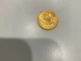une pièce d'or posée sur une table blanche