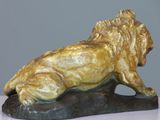 statue of a lion laying on a rock on a table
