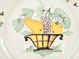 a plate with a painting of a basket of fruit on it