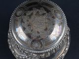 an antique silver plate with a floral design on it