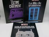 trois livres posés sur une table blanche, avec une horloge et une lampe