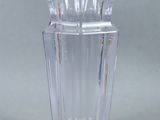 a clear glass vase with a silver lid on a table