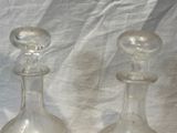 two clear glass vases sitting on a white cloth