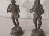 paire de figurines en bronze représentant un homme et une femme, posées sur un socle