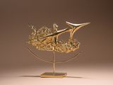 une sculpture en or représentant un bateau, posée sur un socle
